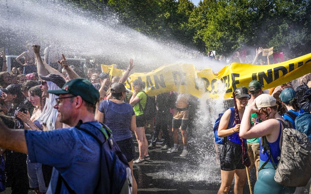 De politie zet waterkanonnen in tegen klimaatactivisten van Extinction Rebellion die de Utrechtsebaan op de A12 in Den Haag blokkeren. De demonstranten vinden dat de overheid direct moet stoppen met het verlenen van fossiele subsidies. Daaronder verstaan de activisten alle financiele regelingen die het gebruik van fossiele brandstoffen bevoordelen. beeld ANP, Phil Nijhuis