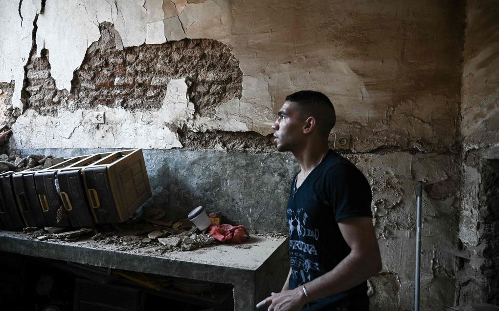 Een inwoner van Marrakesh in een door de aardbeving beschadigd gebouw. beeld AFP, Philippe Lopez