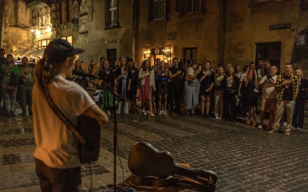 In Lviv, in het westen van Oekraïne, zingen mensen op straat het volkslied. Beeld AFP, Roman PILIPEY