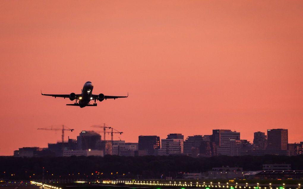 Een vliegtuig stijgt op in het ochtendlicht op luchthaven Schiphol. beeld ANP, JEFFREY GROENEWEG