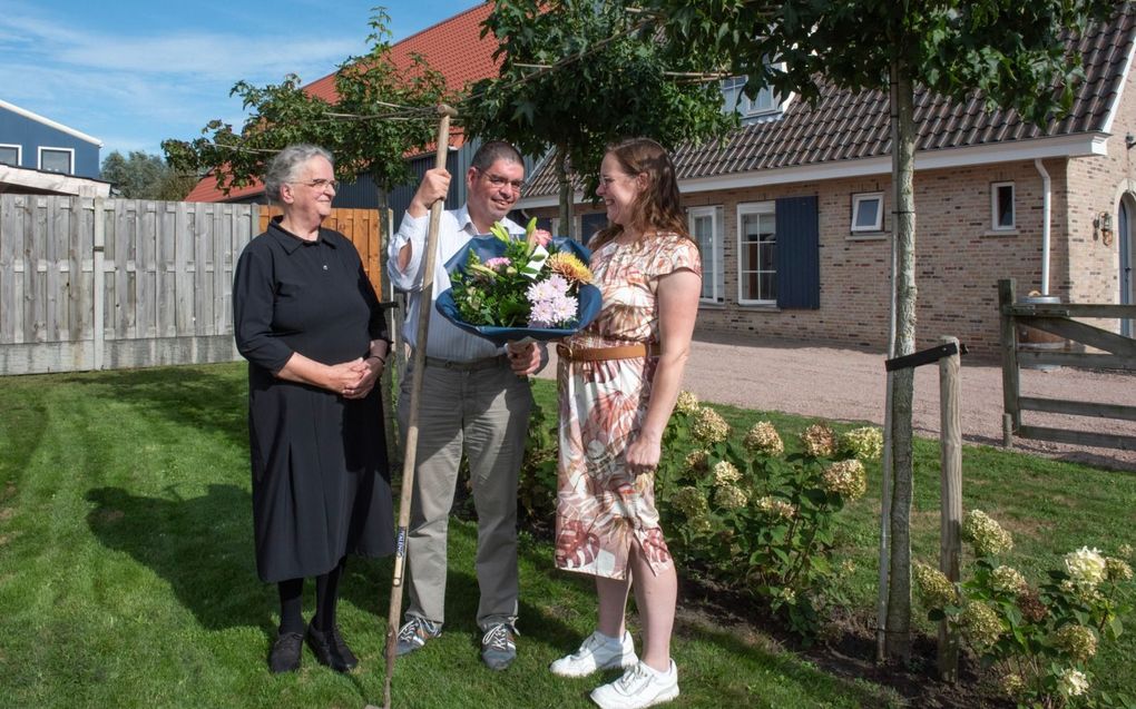 Peter Rijstenbil (m.) geeft zijn zus Ella van den Berg (r.) een bos bloemen. Zijn tante, Betsy Hage (l.), heeft het initiatief op touw gezet. „Ella zorgt goed voor haar broer,” zegt Hage. beeld Henk Copier