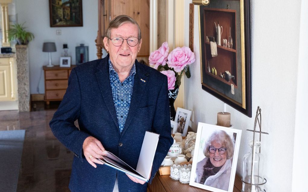 HVC-oprichter Jan Bor naast een portret van zijn vrouw Riet, die in 2022 overleed. Ook zij was sterk betrokken op de vervolgde kerk. beeld RD, Anton Dommerholt