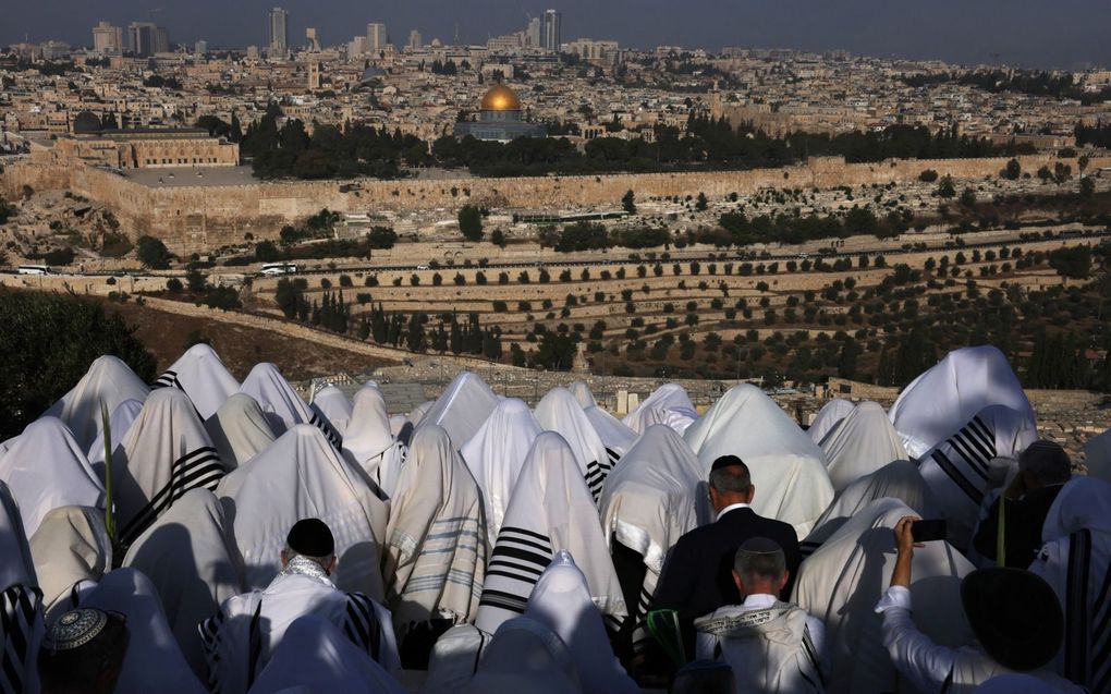 Orthodoxe Joden bidden op de Olijfberg tijdens het Joodse loofhuttenfeest, vorige week. beeld AFP, Menahem Kahana