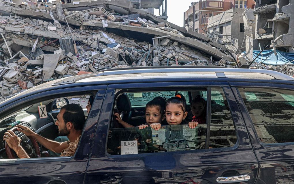 Palestijnen rijden door verwoestingen als gevolg van Israëlische luchtaanvallen in Rafah, in de Gazastrook. beeld AFP, Said Khatib