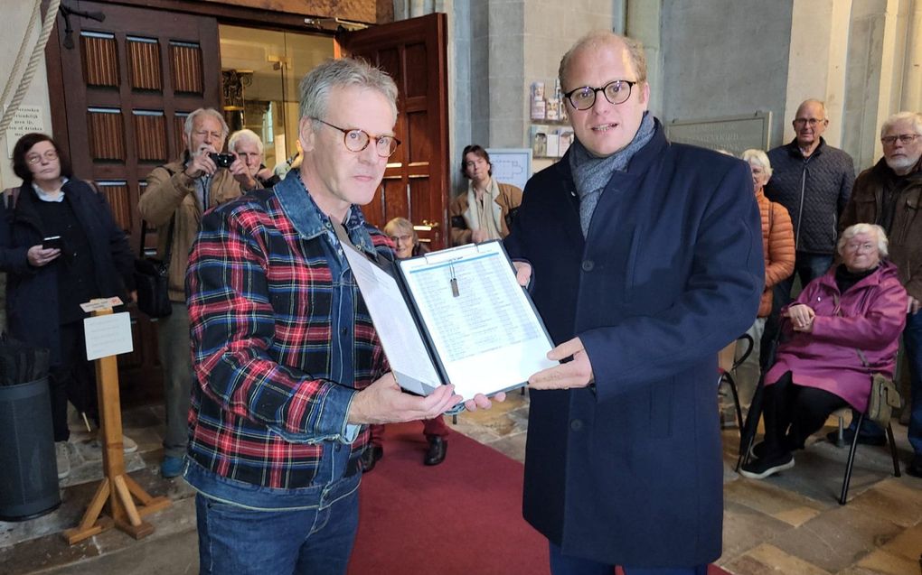Beiaardier Wim Ruessink (l.) overhandigt de petitie aan burgemeester Bengevoord van Winterswijk. beeld Kitty de Fauw