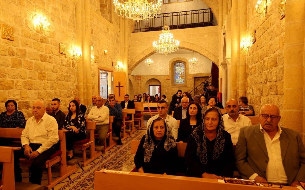 Palestijnse christenen maandag tijdens een dienst in Jifna, nabij Ramallah, ter nagedachtenis aan getroffenen bij een Israëlische aanval nabij de kerk van Sint Porphyrius in Gaza. beeld AFP, Jaafar Ashtiyeh