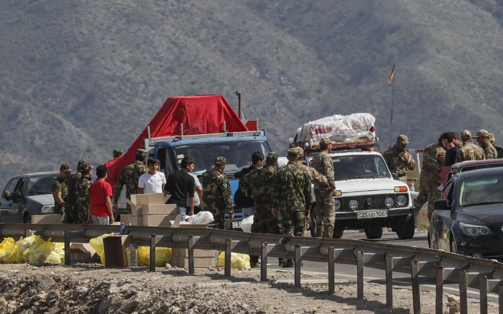 Ruim 100.000 etnisch Armeense inwoners uit Nagorno-Karabach sloegen uit angst voor etnische zuiveringen op de vlucht. Armeense militairen controleren de vluchtelingen. beeld EPA, Anatoly Maltsev