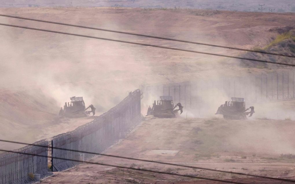 Gepantserde Israëlische bulldozers trekken de grens met de Gazastrook over. beeld AFP, Menahem Kahana