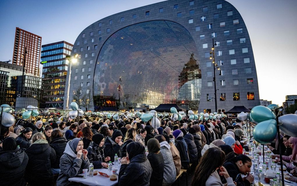 Moslims en niet-moslims delen de iftarmaaltijd, die na zonsondergang wordt gegeten tijdens de ramadan, op het plein voor de markthal in Rotterdam. beeld ANP, Robin Utrecht