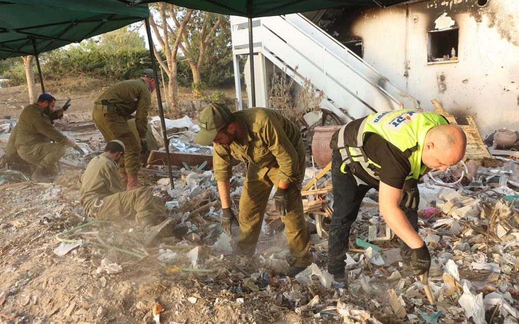 Soldaten en vrijwilligers van noodhulporganisatie ZAKA doorzoeken het puin in kibboets Be’eri. Christenen voor Israël steunt ZAKA. beeld AFP, Gil Cohen-Magen