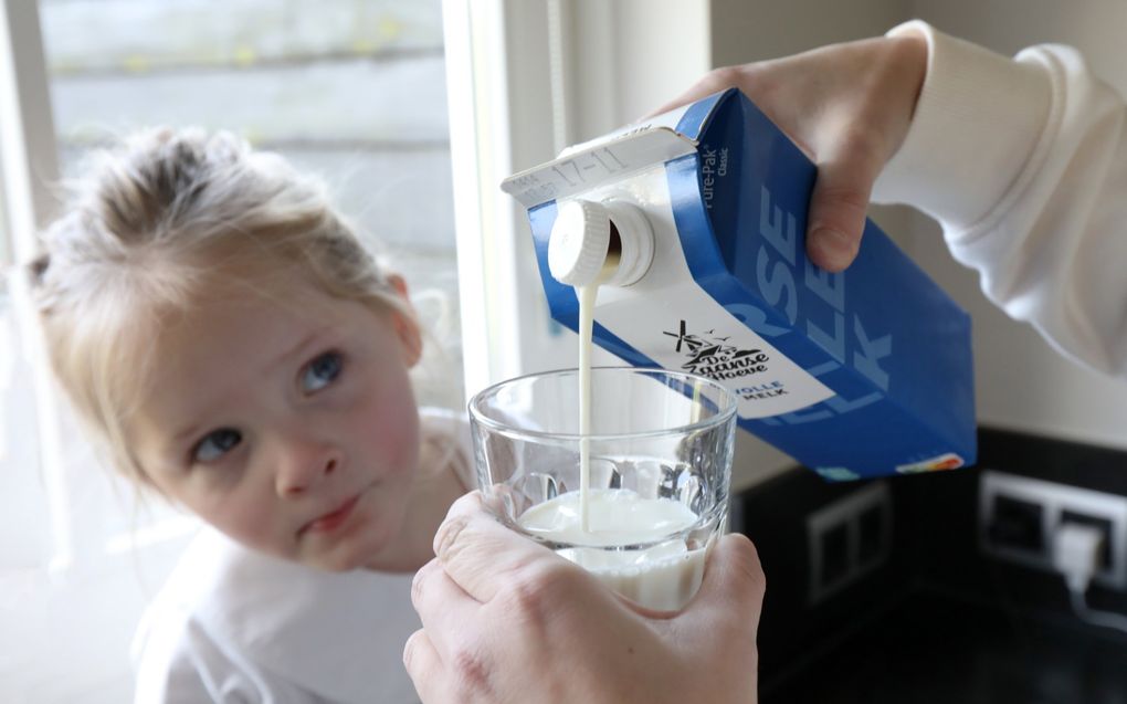 Aline van Noort schenkt voorzichtig melk in terwijl haar driejarige dochtertje Lynthe toekijkt. beeld VidiPhoto