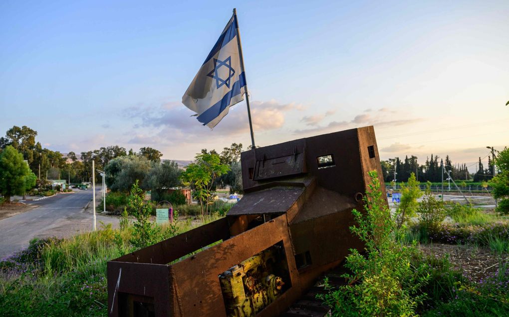 Een Israëlische vlag wappert boven een oude gepantserde tractor, die tussen 1948 en 1967 werd gebruikt in een nederzetting bij de Libanese grens. beeld AFP, John MacDougall