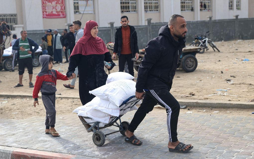 Palestijnen ontvangen dinsdag zakken meel in het vluchtelingenkamp Rafah in de zuidelijke Gazastrook. beeld AFP, Said Khatib