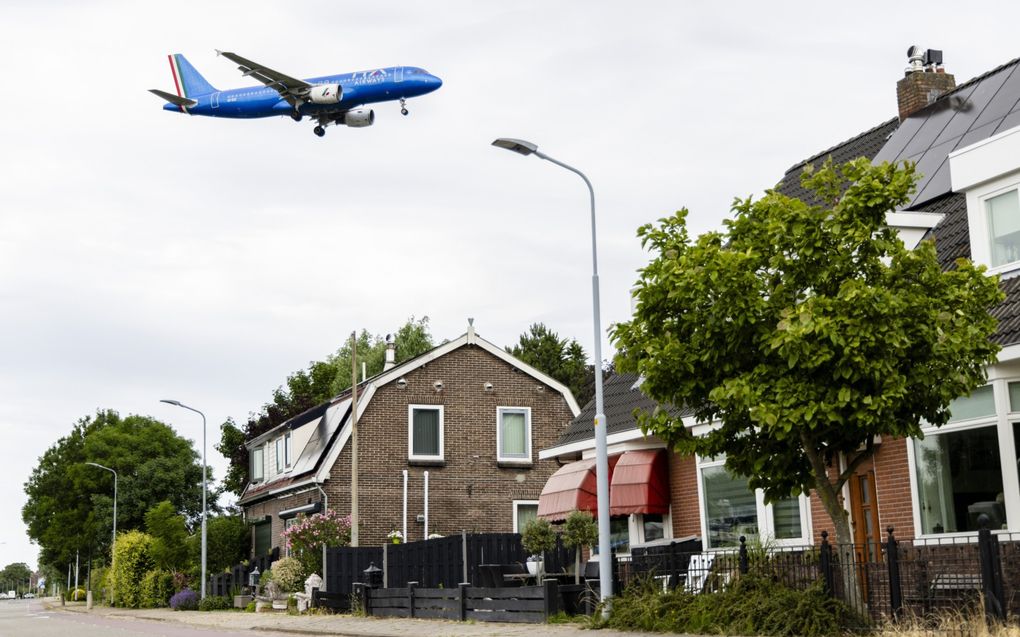 Een vliegtuig vliegt over een woning in de omgeving van Schiphol. beeld ANP, Jeffrey Groeneweg