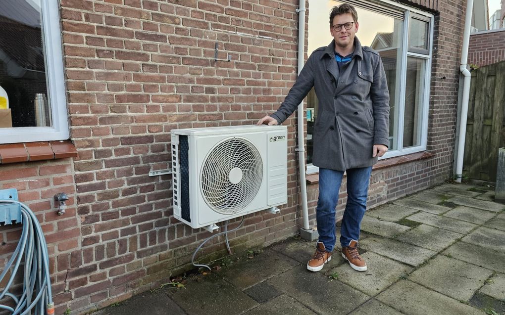 Niels Bioch bij de buitenunit van een van zijn airco’s. beeld Niels Bioch