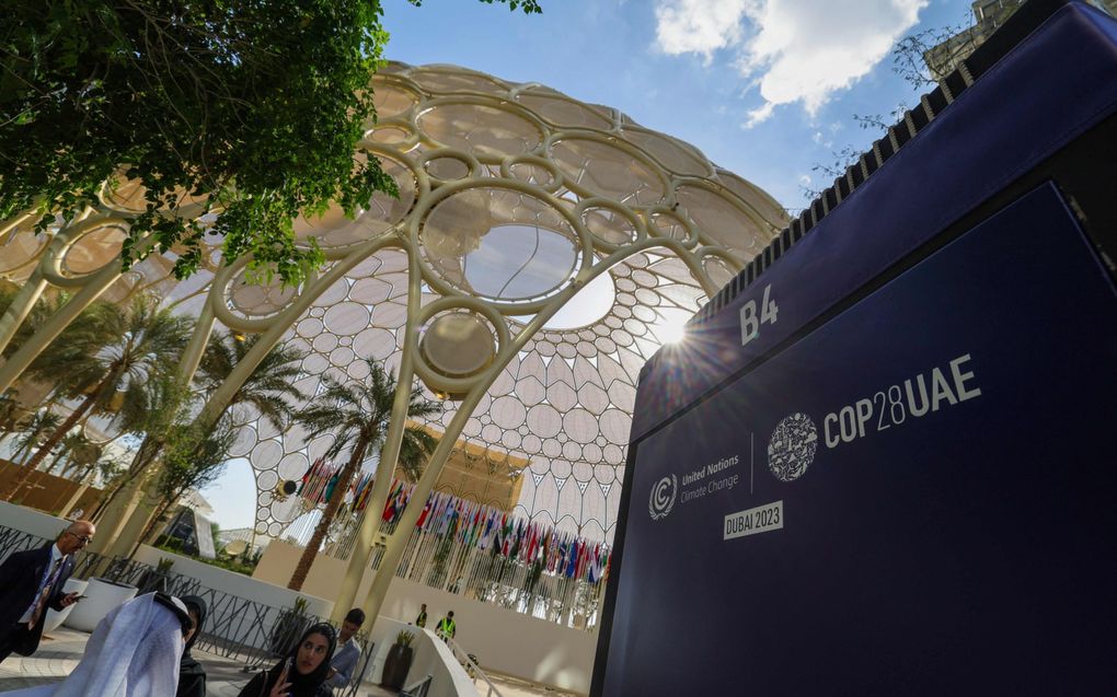 Mensen arriveren op de locatie in Dubai waar donderdag de VN-klimaattop start. De conferentie begint terwijl er veel gaande is op het wereldgebeuren. beeld AFP, Giuseppe Cacace