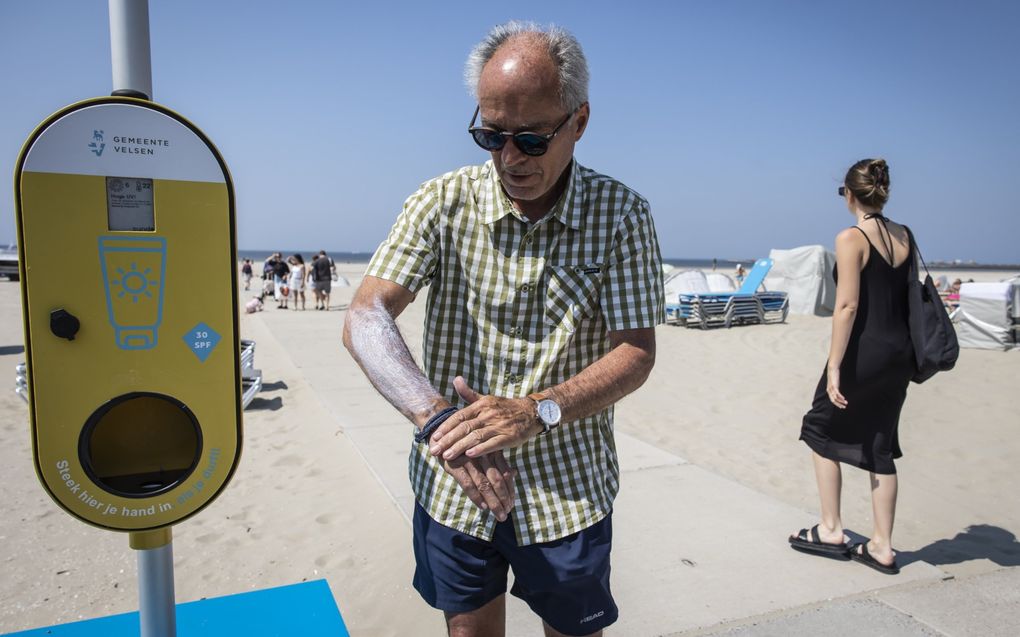 Een paal met gratis zonnebrandcrème bij een strandopgang in IJmuiden. De Zeeuwse GGD is van plan om meer van dit soort palen, maar ook bomen en schaduwdoeken bij strandovergangen te plaatsen om bezoekers te beschermen tegen uv-straling.  beeld ANP, Dingena Mol