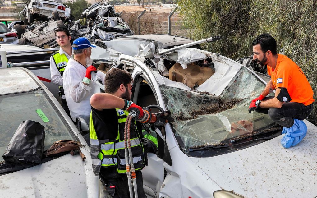 Vrijwilligers van de Joodse orthodoxe organisatie Zaka inspecteren autowrakken in Netivot, op zoek naar menselijke resten. Op die plaats zijn de voertuigen verzameld die bij de aanslagen van 7 oktober werden verwoest. beeld AFP, Jack Guez