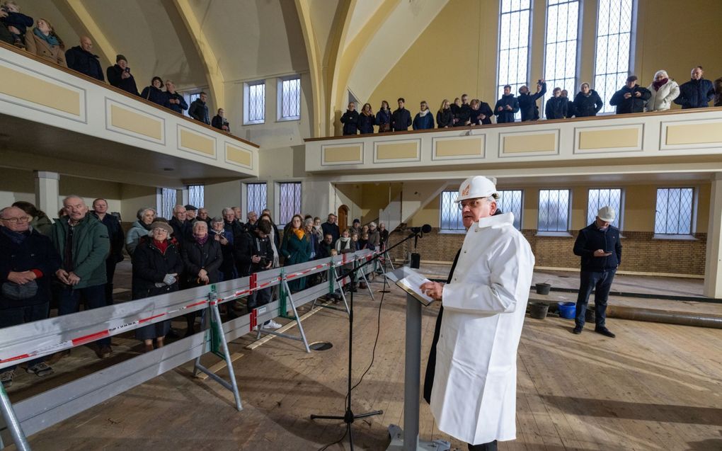 Ds. D.W. Tuinier sloeg zaterdag de eerste paal voor de nieuwe betonvloer van de Poortkerk van de gereformeerde gemeente in Kampen. Tijdens de verbouwing kerkt de gemeente in de Bovenkerk. De Poortkerk aan de 2e Ebbingestraat dateert uit 1951. beeld Freddy Schinkel