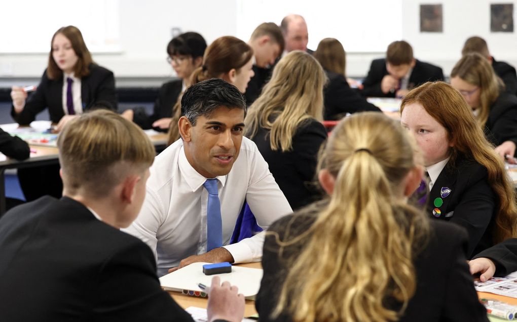 De Britse premier Rishi Sunak in gesprek met leerlingen tijdens een bezoek aan een school nabij Boston. beeld AFP, Darren Staples