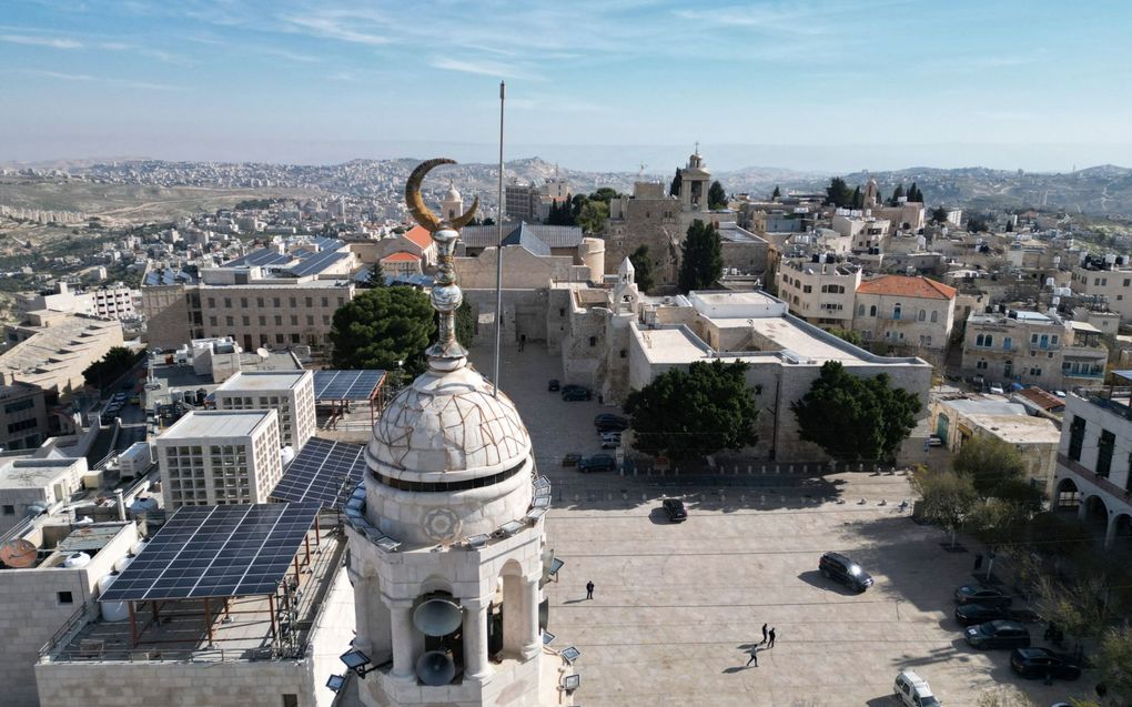 Bethlehem bevindt zich op de Westelijke Jordaanoever, Palestijns –islamitisch– gebied. De foto toont, naast de minaret van een van de vele moskeeën, een leeg plein voor de Geboortekerk. Op deze plek zou de Heere Jezus geboren zijn. Normaal stroomt de Bijbelse stad in december over met toeristen. Kerkleiders besloten afgelopen maand „alle onnodige feestelijke” kerstactiviteiten af te blazen „uit solidariteit met de Gazanen”. beeld AFP, Hazem Bader