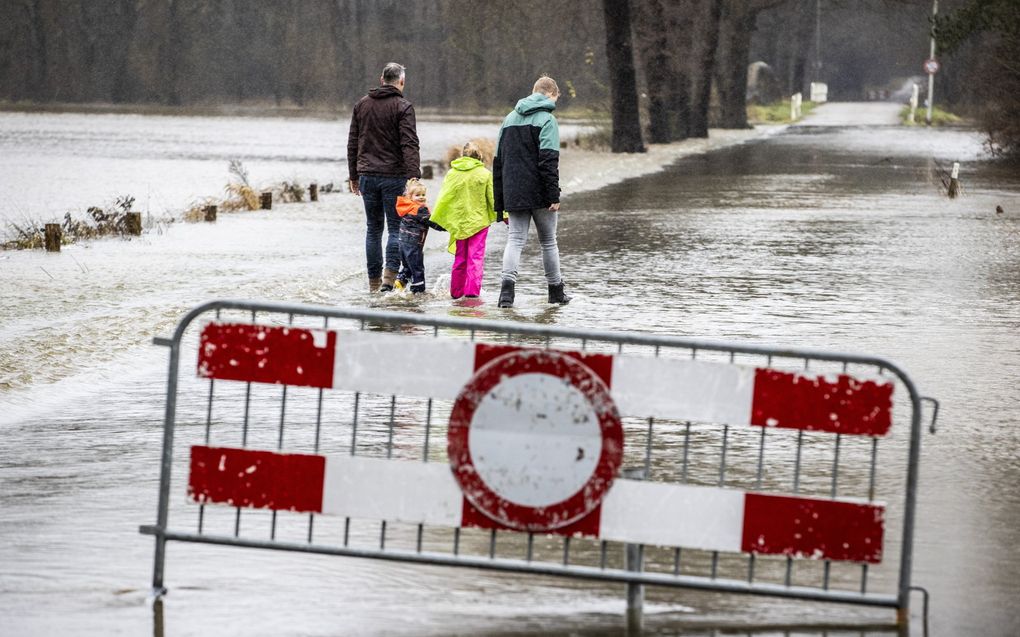 Rivier De Dinkel treedt buiten haar oevers en stroomt over een weg in het buitengebied tussen Losser en De Lutte. beeld ANP, VINCENT JANNINK