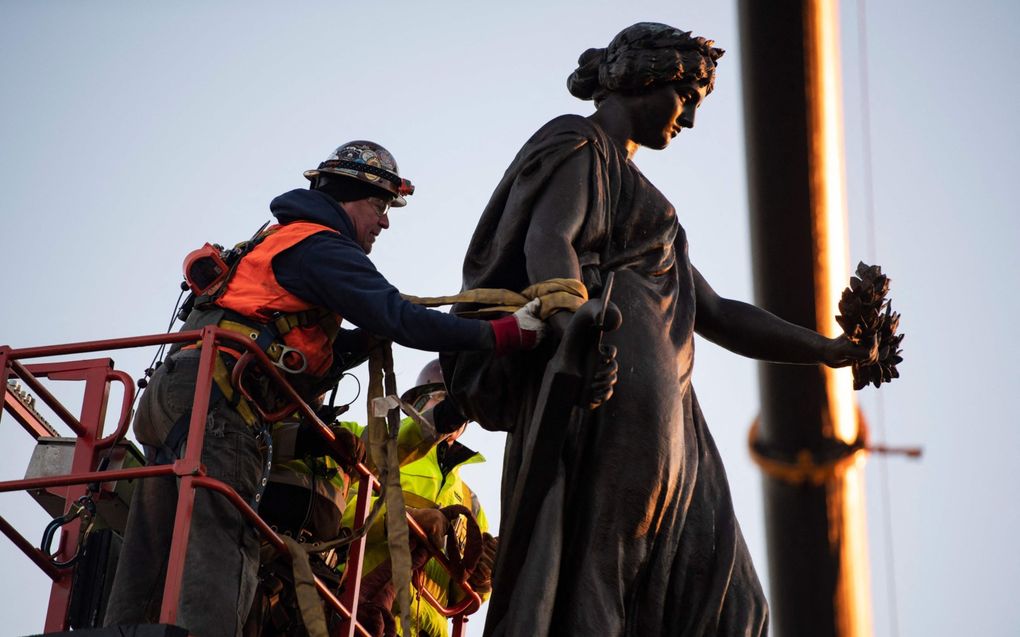 Arbeiders verwijderen het Conferatiemonument op de nationale begraafplaats Arlington. Na de gewelddadige dood van Afro-Amerikaan George Floyd werden in de strijd tegen structureel racisme zo’n duizend monumenten verplaatst. beeld AFP, Arlington National Cemetery