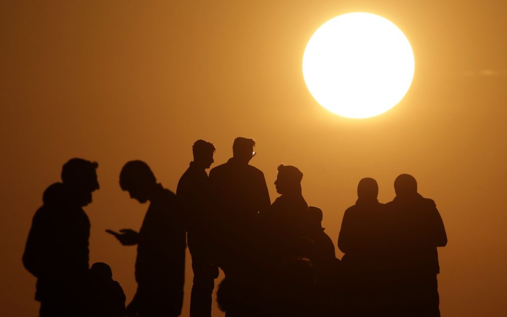 Palestijnen in de Gazastrook proberen zaterdag internetsignaal op hun mobieltje op te vangen. Door de oorlog is er slechts zeer onregelmatig verbinding met de buitenwereld mogelijk. beeld EPA, Mohammed Saber