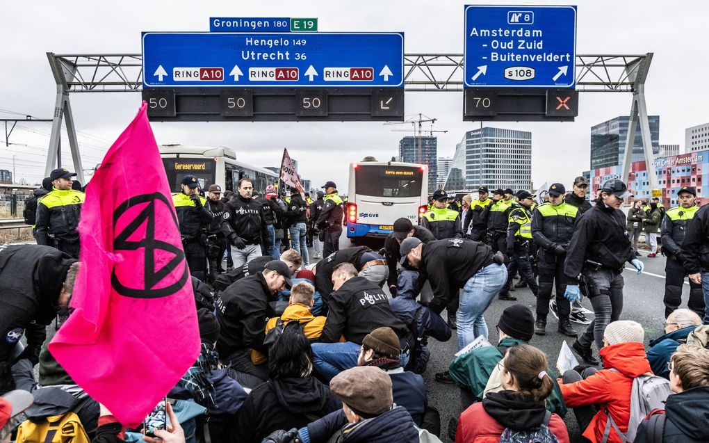 Demonstranten van Extinction Rebellion tijdens een blokkade van de snelweg A10 bij het voormalig ING-hoofdkantoor op de Zuidas in december. beeld ANP, Eva Plevier