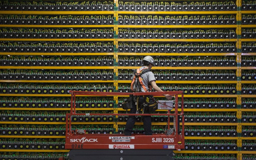 Een technicus in het Canadese Saint Hyacinthe inspecteert apparatuur voor ”minen” van bitcoins. Dat proces vergt veel energie. beeld AFP, Lars Hagberg