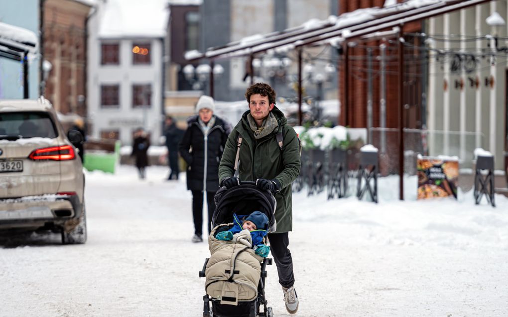 Een jonge vader achter de kinderwagen. Steeds meer vaders nemen zorgtaken in het gezin op zich. Het  combineren van een baan en zorgen voor kleine kinderen is voor menig ouder stressvol. beeld iStock