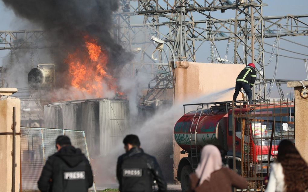 Brandweerlieden proberen na een Turkse aanval de brand in de elektriciteitscentrale in Qamishli in Noordoost-Syrië te blussen. beeld EPA, Ahmed Mardnli