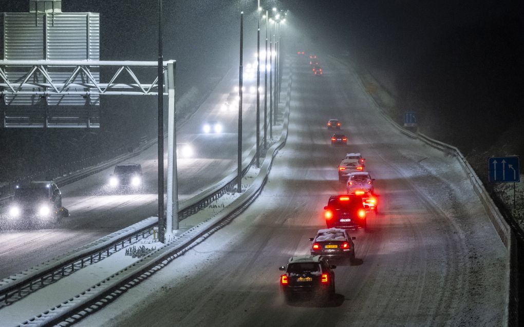 Verkeer rijdt over een met sneeuw bedekte snelweg A76. Rijkswaterstaat riep woensdagavond op de snelwegen in Limburg om sneeuw te mijden. beeld ANP, Marcel van Hoorn