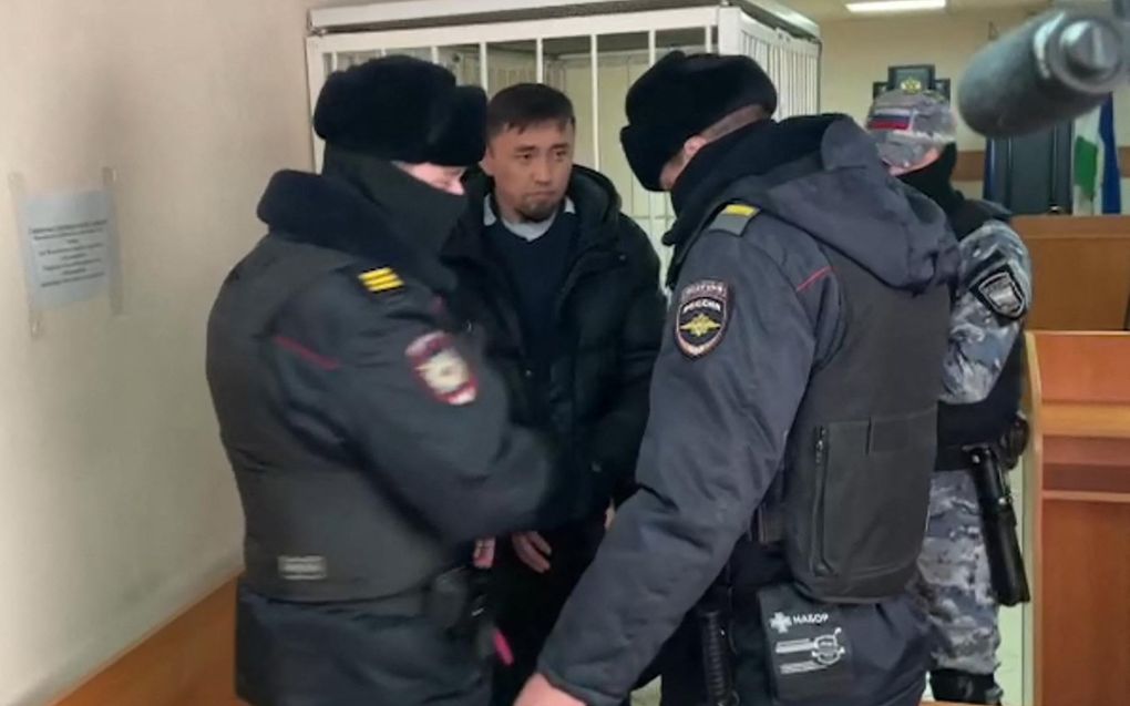 Anti-oorlogsactivist Fail Alsynov tussen agenten in de rechtbank van Bajmak. beeld AFP