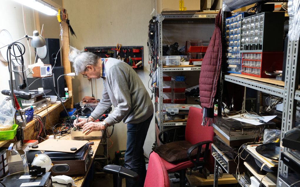 Aan verschillende werkbanken zijn mannen aan het werk. Ze testen koffiemachines, tv’s en audioapparatuur. beeld RD, Anton Dommerholt