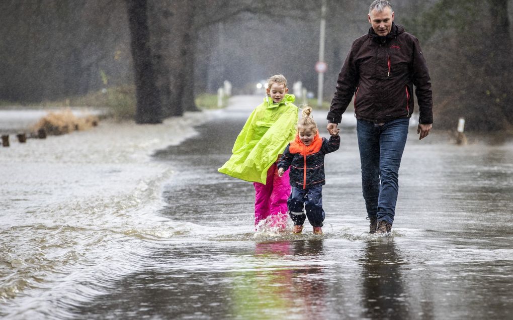 Regenjassen en regenlaarzen waren eind vorig jaar geen overbodige luxe. Zo ook bij de De Dinkel in Twente. De rivier trad in december door de aanhoudende neerslag buiten haar oevers.  beeld ANP, Vincent Jannink