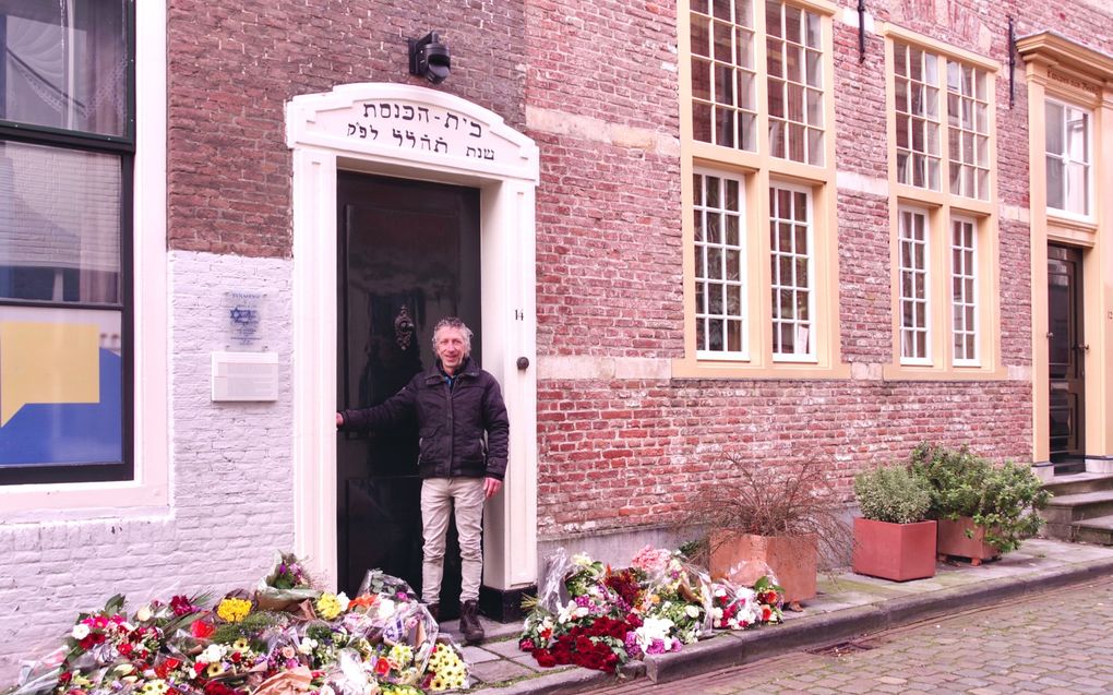 Willem Dane bij de bloemen die maandag in Middelburg voor de ingang van de op twee na oudste synagoge van Nederland zijn gelegd nadat deze was beklad. beeld Van Scheyen Fotografie