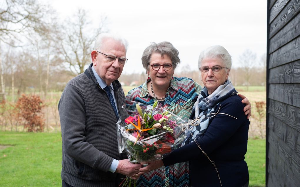 Johan en Ria Diepeveen krijgen van hun dochter Arri Zwolsman (m.) een bos bloemen. „Mijn ouders kijken eerst of iemand anders hulp nodig heeft voordat ze aan zichzelf denken.” beeld Speechless Photography