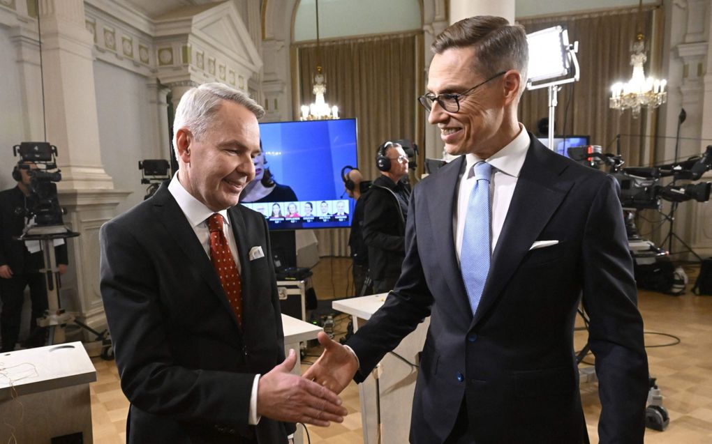 De Finse presidentskandidaten Pekka Haavisto (l.) en Alexander Stubb schudden elkaar na een debat de hand. beeld AFP, Markku Ulander