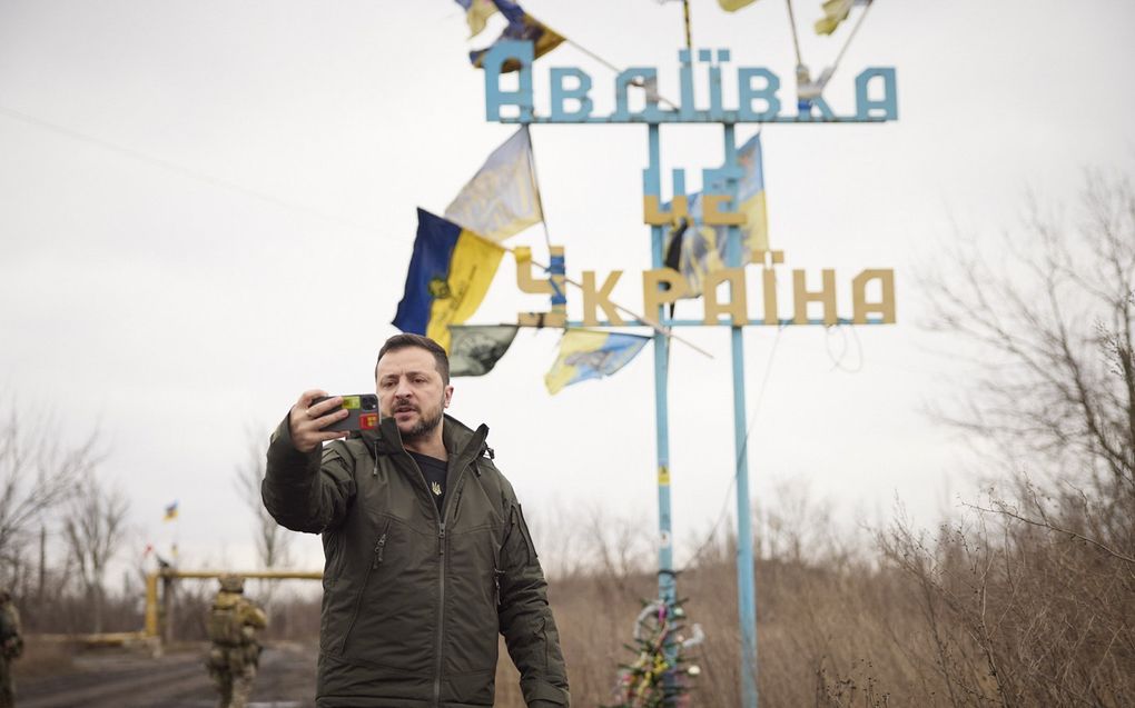 Oekraïense president Volodymyr Zelenski neemt een videotoespraak op voor het bord “Avdiivka is Oekraïne”. beeld EPA