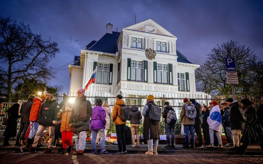 Mensen komen vrijdag samen bij de Russische ambassade in Den Haag om een wake te houden voor de overleden oppositieleider Navalni. beeld ANP, Robin Utrecht