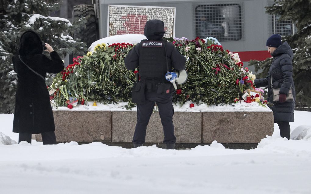 Aanhangers van Navalny leggen zaterdag in Moskou, onder toeziend oog van de politie, bloemen bij een gedenkteken voor politieke gevangenen. beeld EPA, Sergei Ilnitsky