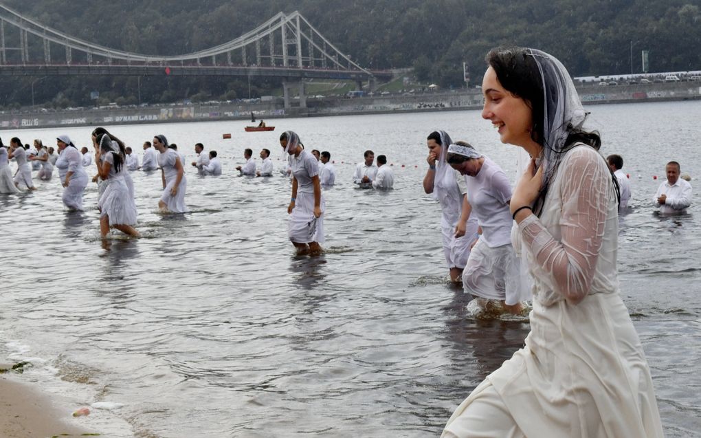 Doop van jonge gelovigen in de Djnepr bij Kyiv in de zomer van 2018. Veel protestantse kerken zien tijdens de oorlog meer belangstelling voor het Evangelie.  beeld AFP, Sergei Supinsky