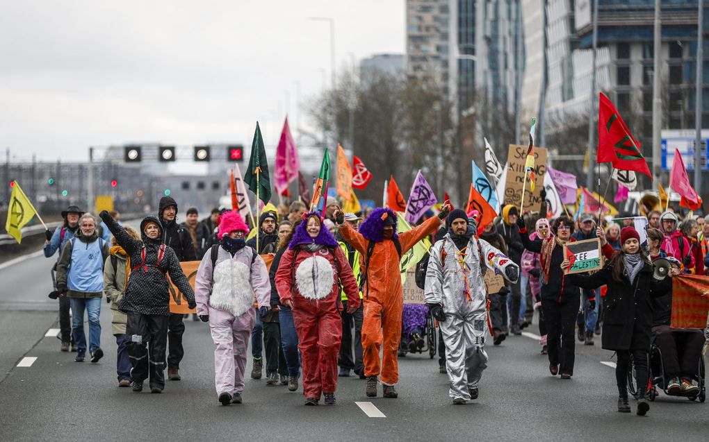 Demonstranten van Extinction Rebellion tijdens een blokkade van de snelweg A10 ter hoogte van het voormalig ING-hoofdkantoor op de Zuidas. Ze eisen dat de bank stopt met alle financiering van, en dienstverlening aan de fossiele industrie.  beeld ANP, Sem van der Wal