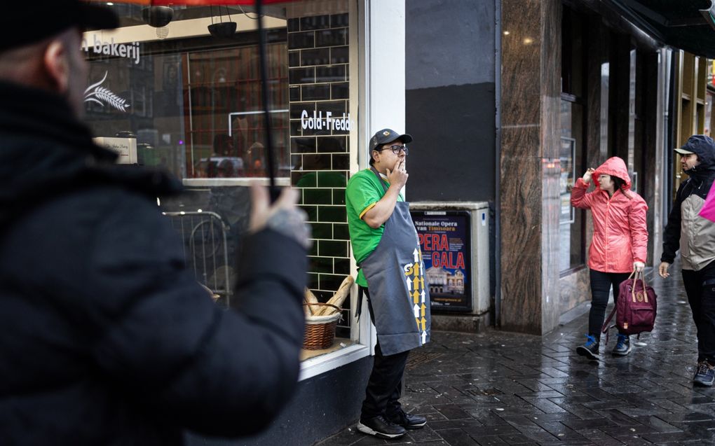 Een man pauzeert van zijn werk in de horeca in de Amsterdamse binnenstad. Na een week werken, moeten mensen op zondag kunnen uitrusten, zeggen de initiatiefnemers achter de jaarlijkse Internationale Dag voor de Werkvrije Zondag op 3 maart. beeld ANP, Ramon van Flymen