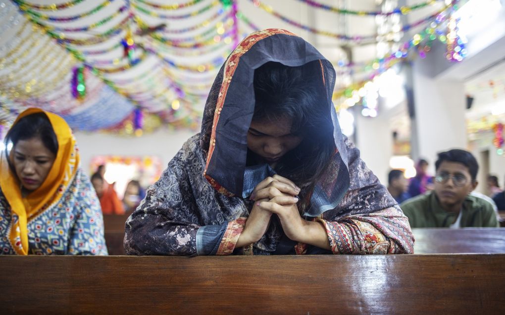 „Nog steeds telt op veel plaatsen in de wereld het verhaal van vrouwen niet mee.” Foto: een christenvrouw uit Bangladesh bidt tijdens de dienst op eerste kerstdag 2023. beeld EPA, Monirul Alam