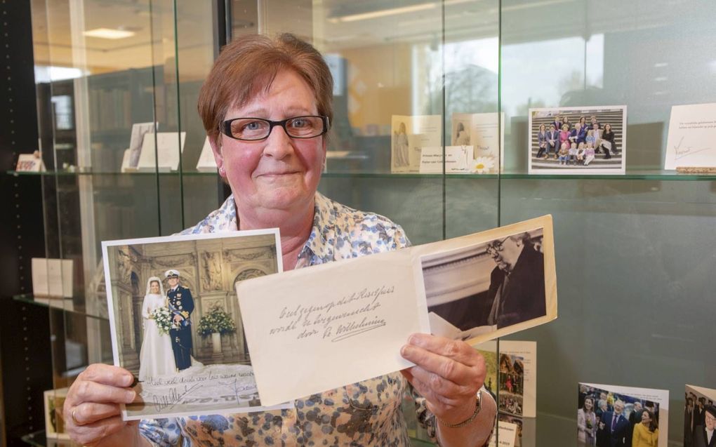 Ria Kooy bij haar verzameling ”Oranje bedankkaartjes”. De bibliotheek in Scherpenzeel exposeert daarover. beeld Herman Stöver