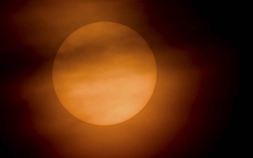 De zon kleurde dinsdag oranje. De oorzaak was zand uit de Sahara, dat zorgde voor breking en verstrooiing van het zonlicht. beeld ANP, Robin van Lonkhuijsen