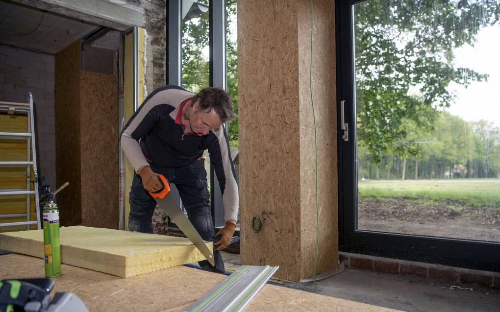 Michiel Snijders aan het klussen in een in 1940 gebouwde soldatenwoning. Met hulp van Energiebespaarfonds maakt de Enschedeër het huis duurzamer.  beeld Ruben Meijerink