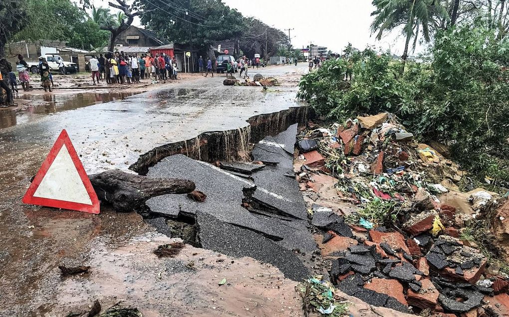 Bewoners in de stad Pemba staan naast een weg die verwoest is door stortbuien als gevolg van de cycloon Kenneth. Nog steeds houdt de regen aan. beeld AFP Bewoners in de stad Pemba staan naast een weg die verwoest is door stortbuien als gevolg van de cyclo